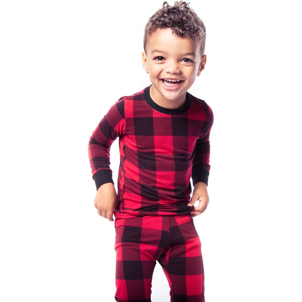 Child wearing red and black checkered pajamas on a white background