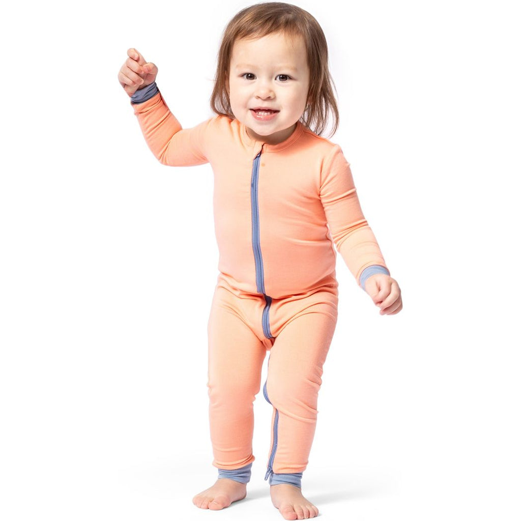 Toddler wearing Apricot Bamboo Zip Sleeper in orange, front view