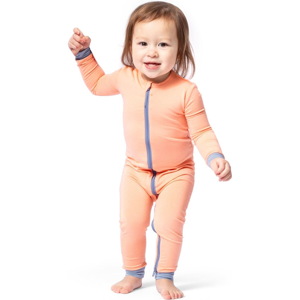 Toddler wearing Apricot Bamboo Zip Sleeper in orange, front view