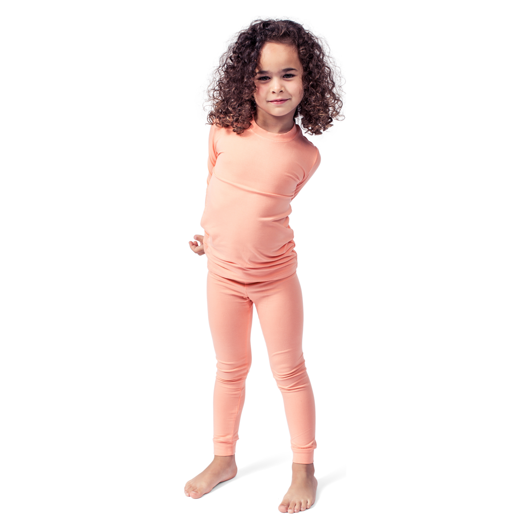 Girl wearing Apricot Kids Bamboo PJs in orange, front view