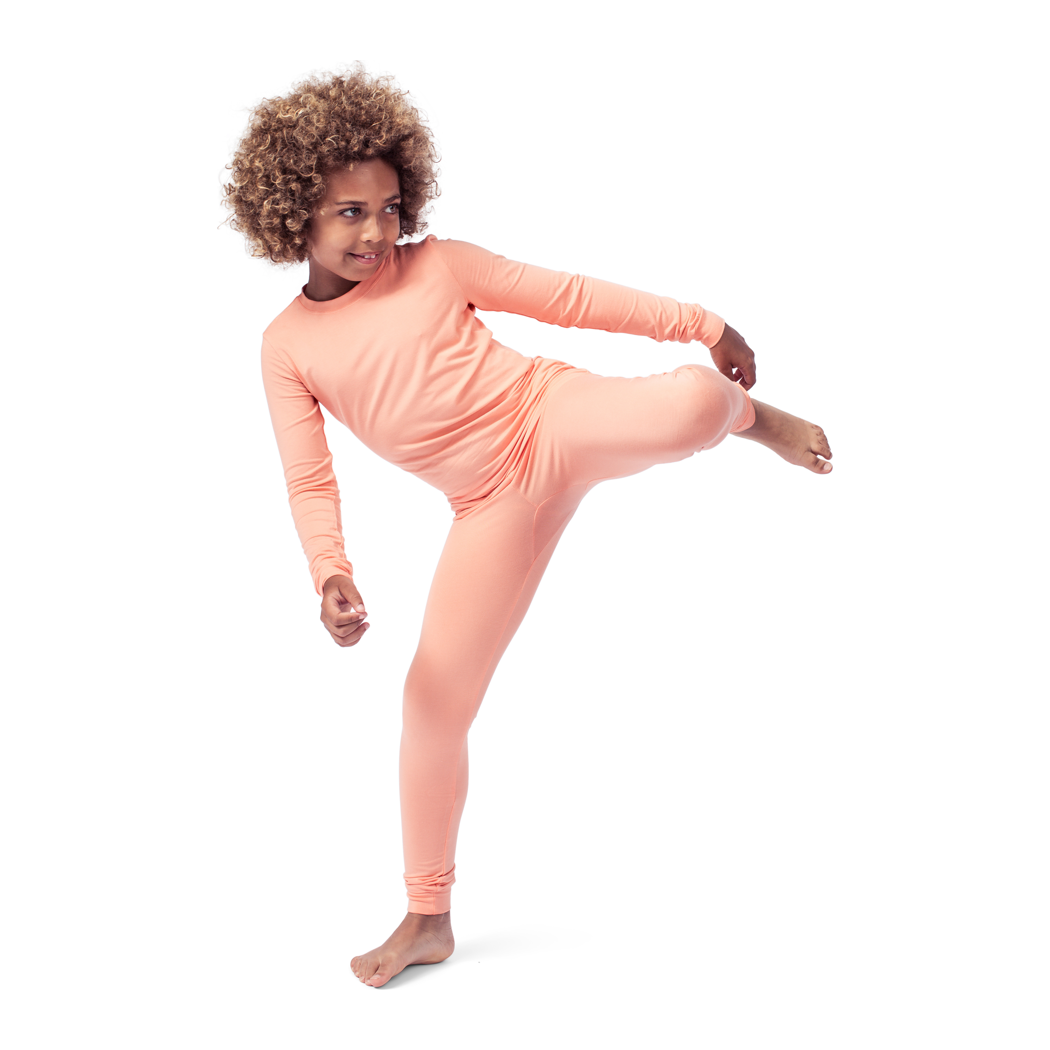 Girl wearing Apricot Kids Bamboo PJs in orange, side view