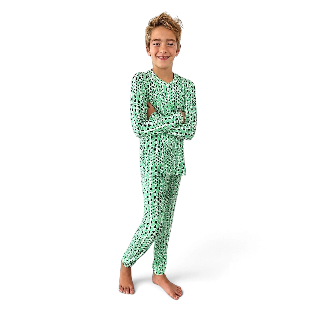 Boy with arms crossed wearing Cactus Bamboo PJs in green and black print