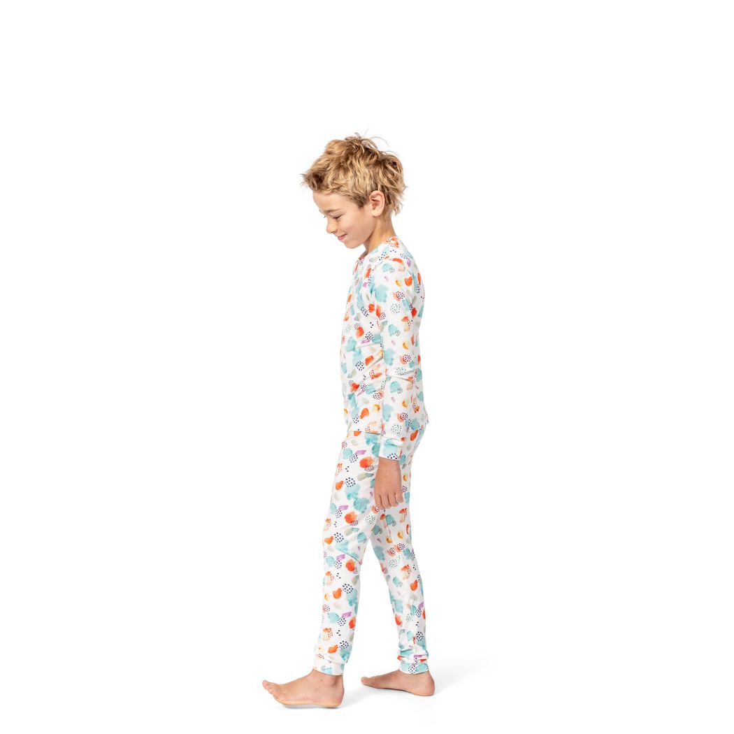 Boy wearing Confetti Cloud Kids Bamboo PJs in multicolor, side view