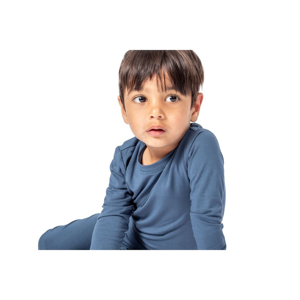 Toddler wearing Denim Kids Bamboo PJs in blue, front view