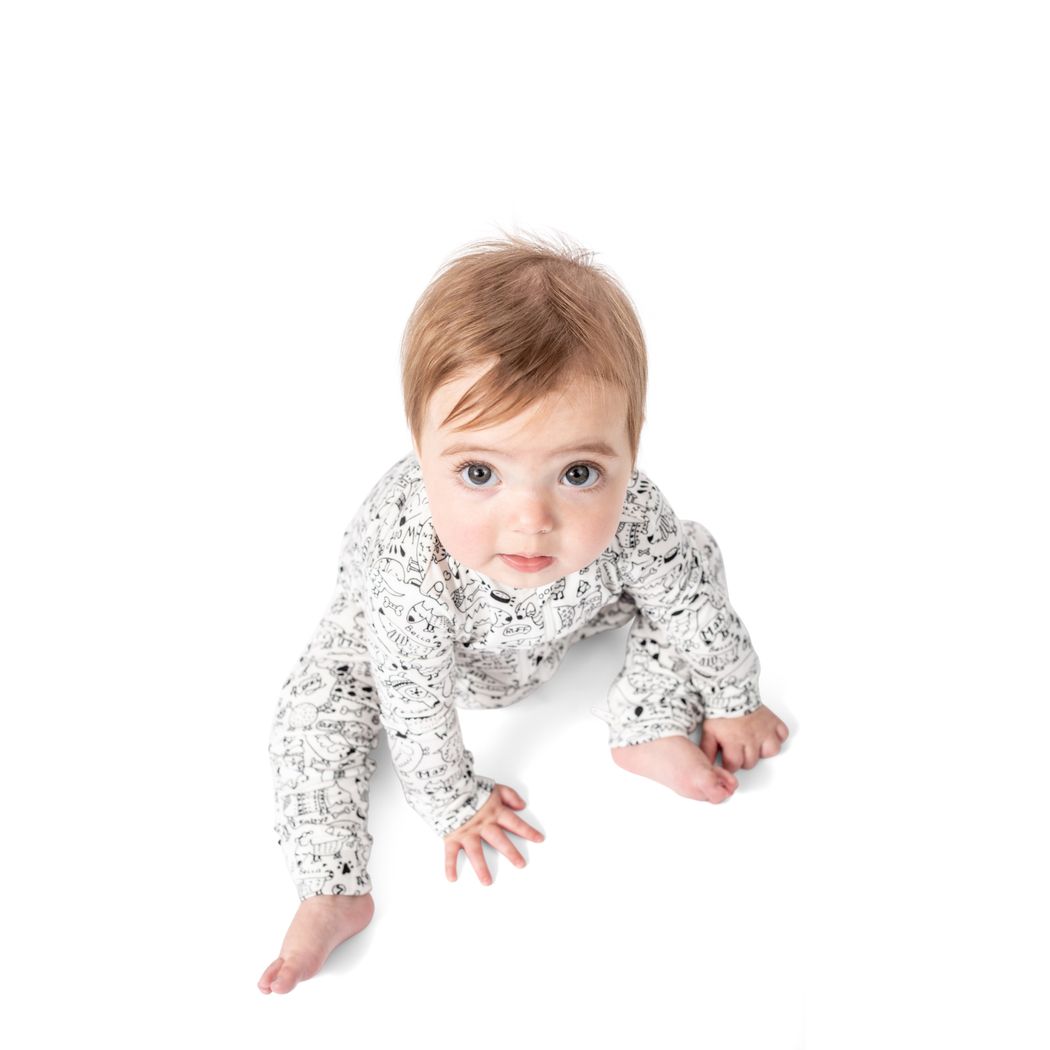 Baby wearing Dog Show Bamboo Zip Sleeper in neutral tones, front view