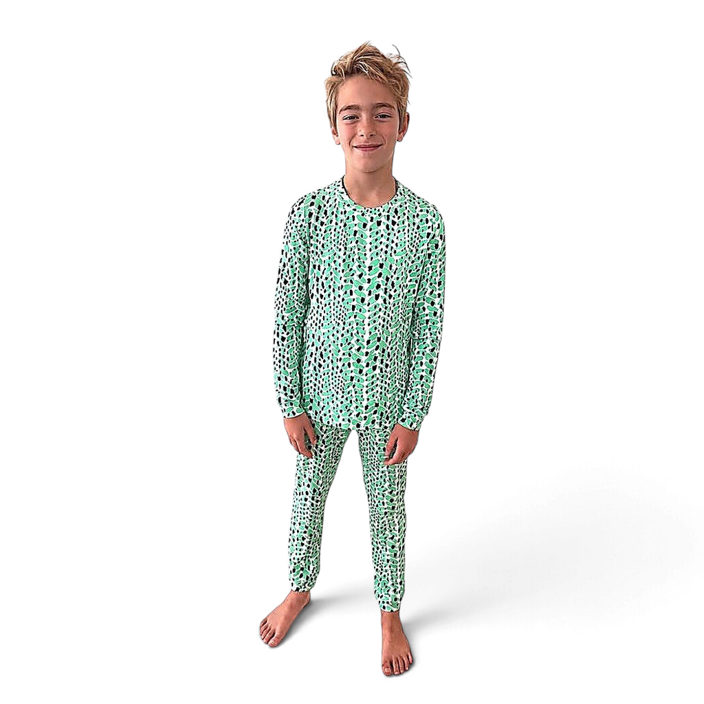 Boy wearing Cactus Bamboo PJs, long-sleeve top and jogger pants in green and black print, front view