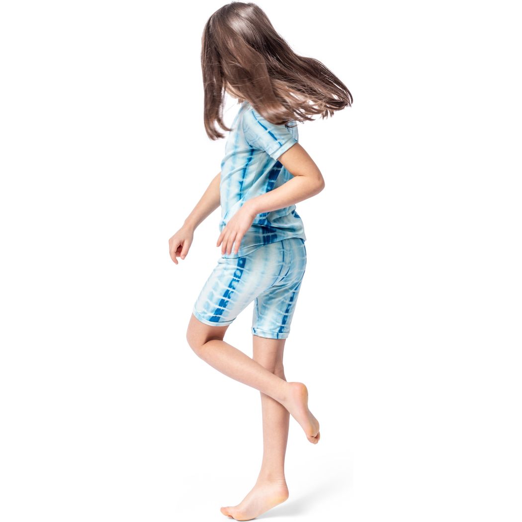 Girl wearing Mykonos Shibori Kids Bamboo Shorties PJ Set in blue, side view