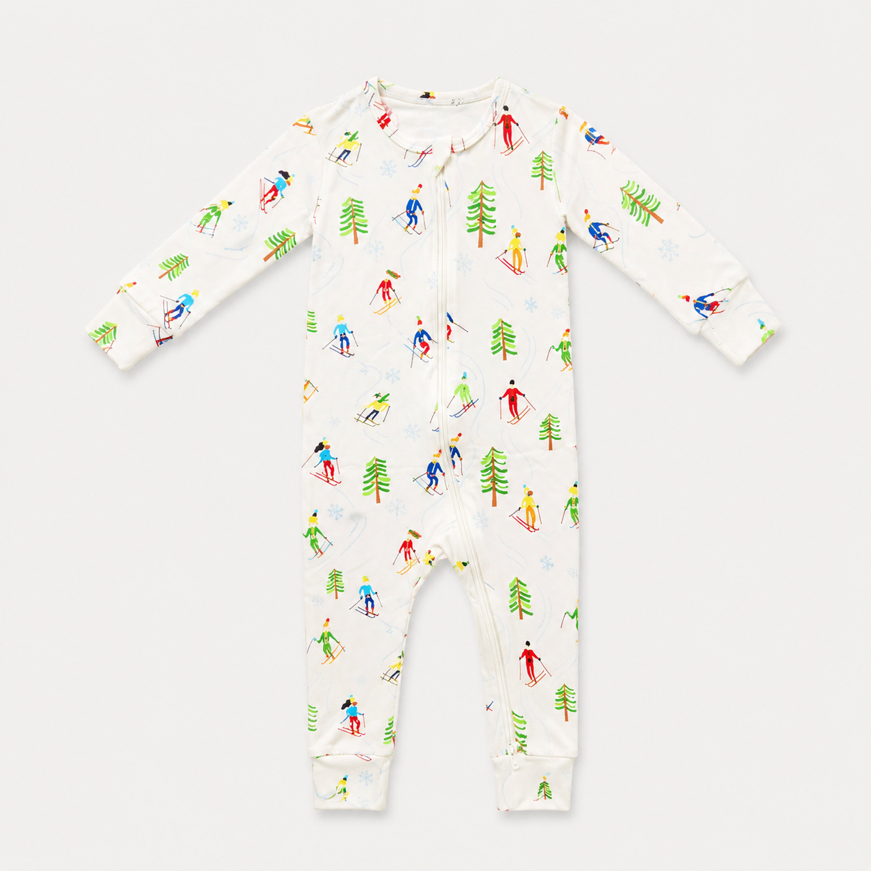 A baby long-sleeve footless one-piece sleeper with a white background and a colorful allover print of skiers and pine trees, shown flat on a light gray background.