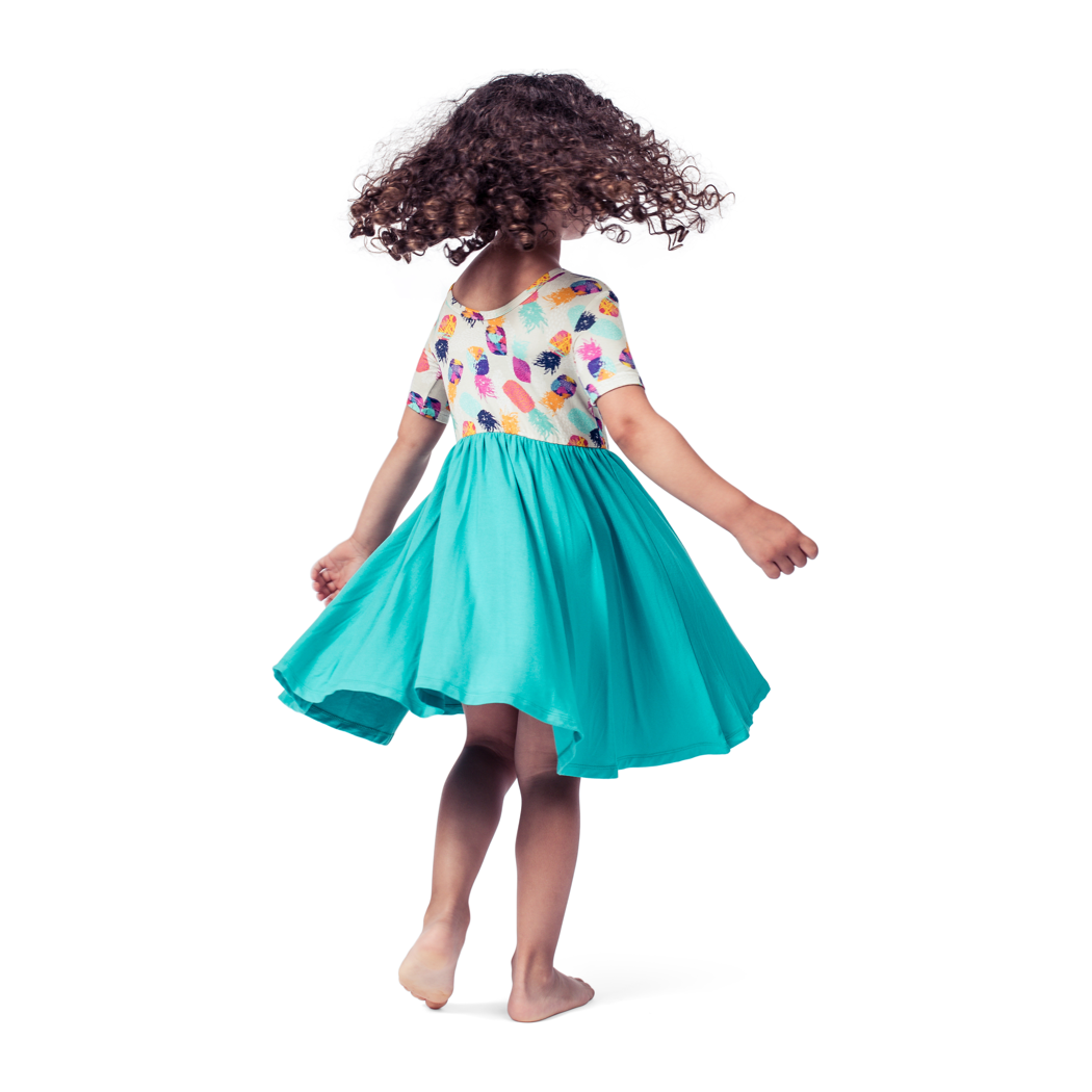 Girl wearing Pineapple Twirl Dress in multicolor, side view