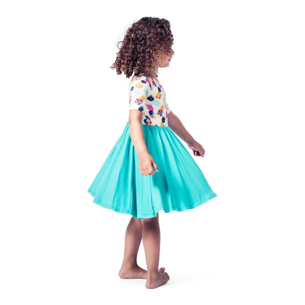 Girl wearing Pineapple Twirl Dress in multicolor, side view