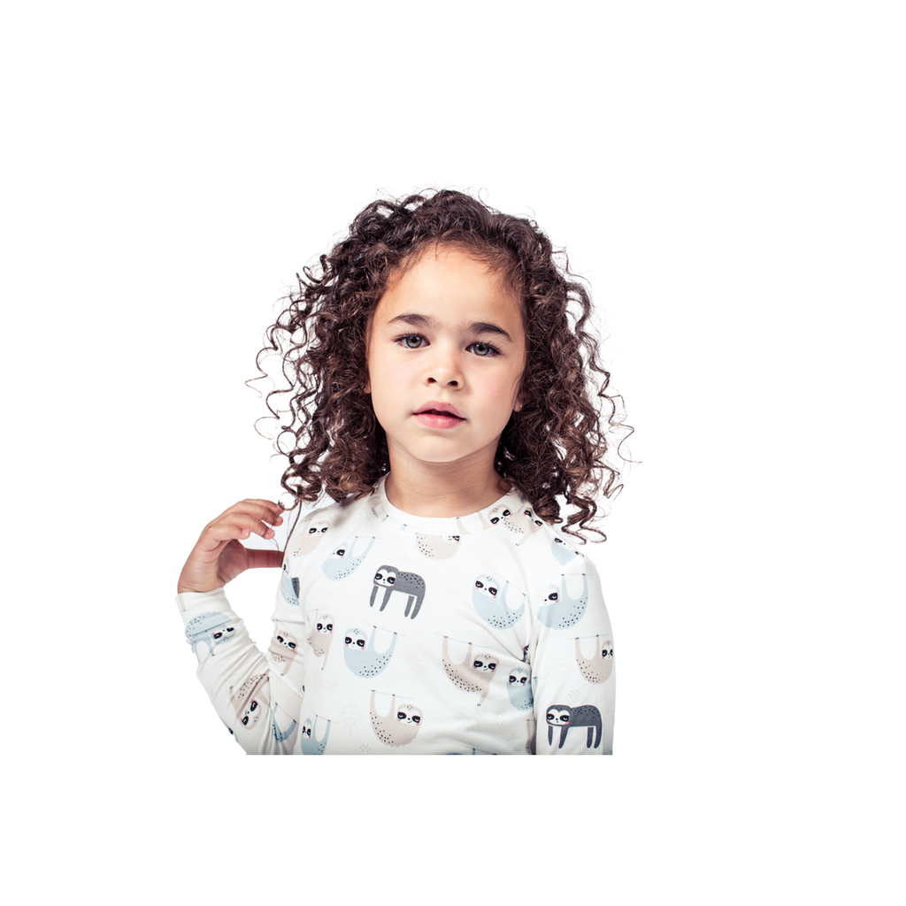 Close-up detail of girl wearing Sloth Kids Bamboo PJs in neutral tones