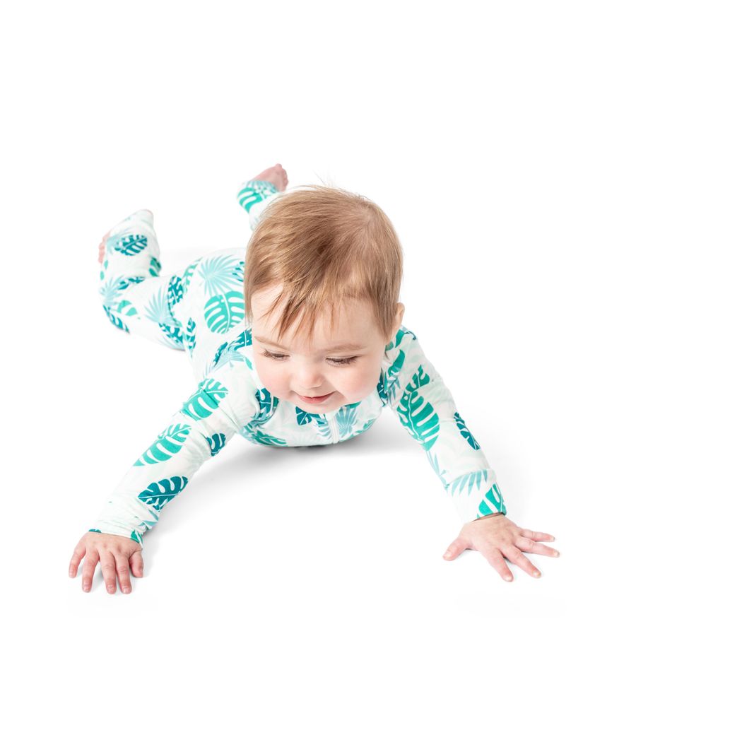 Baby wearing Tropicana Bamboo Zip Sleeper in mint, front view