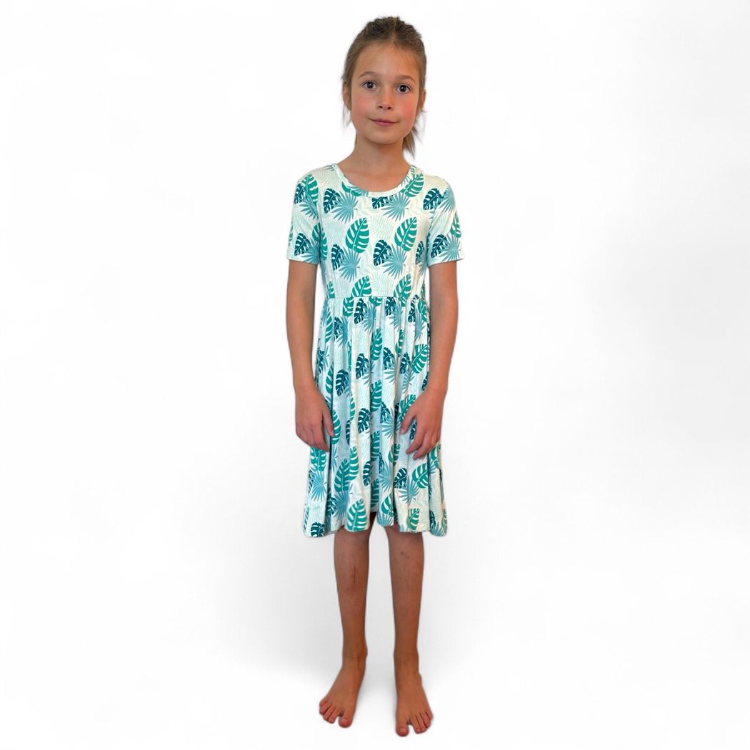 Girl wearing Tropicana Twirl Dress in mint, front view