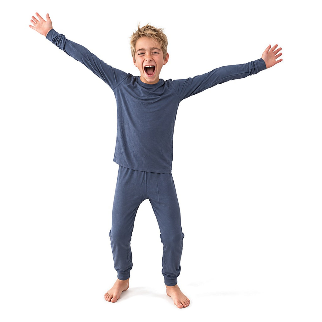 Boy cheering with arms outstretched in Vintage Indigo Bamboo PJs