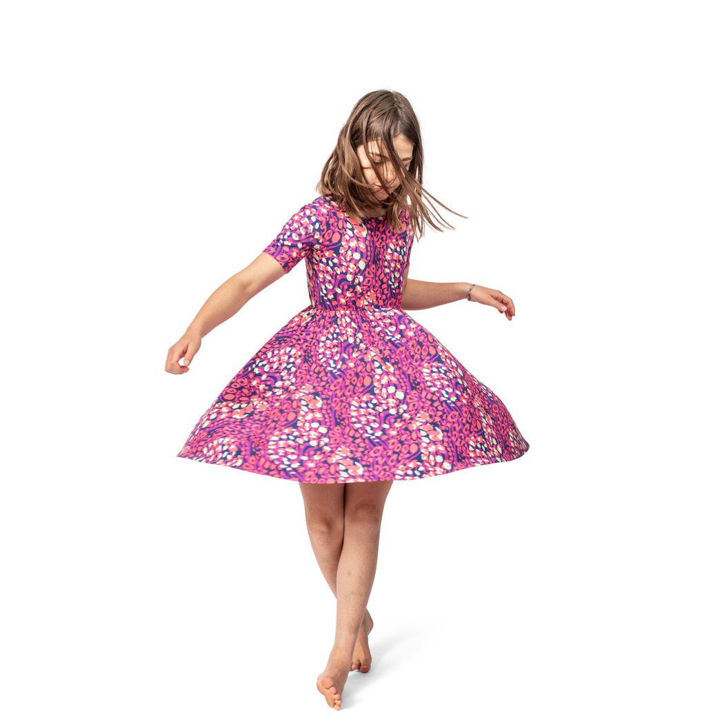 Girl wearing Wild Garden Twirl Dress in pink, front view
