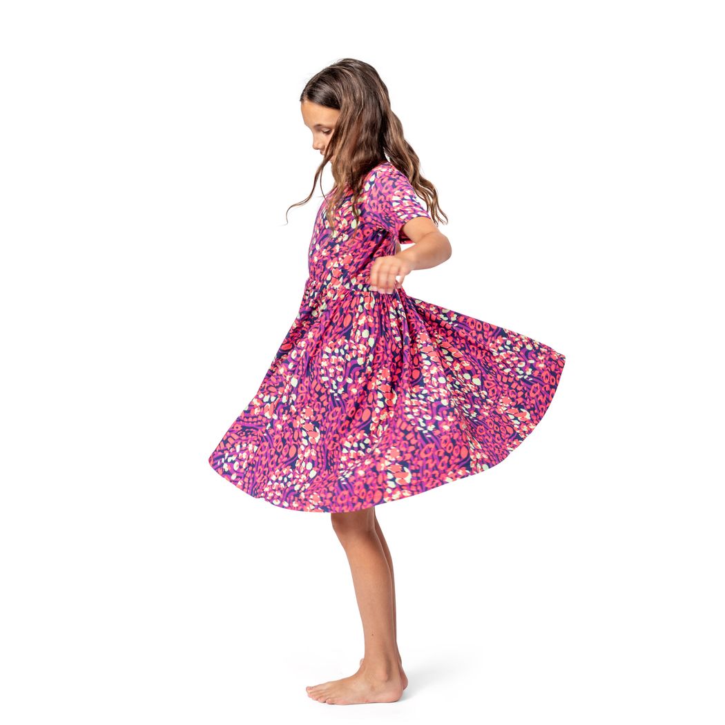 Girl wearing Wild Garden Twirl Dress in pink, side view